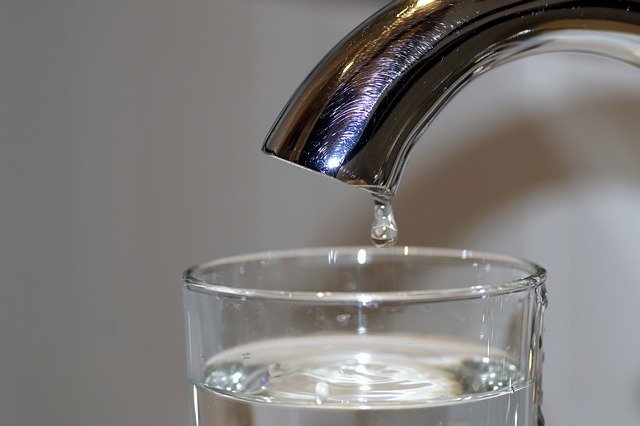 water faucet dripping into drinking glass